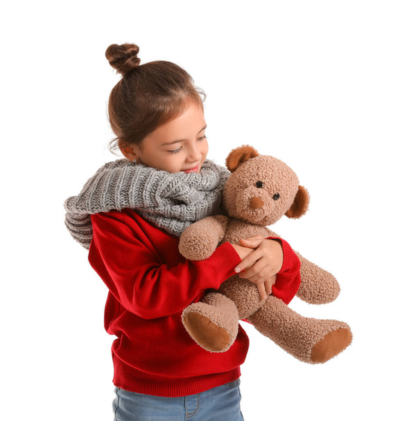 Cute girl in winter clothes and with toy on white background - Fotoğraf, Görsel