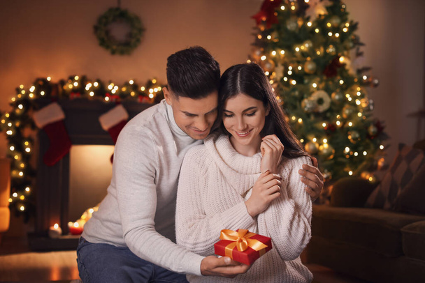 Happy young couple celebrating Christmas at home - Foto, imagen