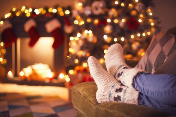 Young woman in warm socks at home on Christmas eve - Foto, imagen