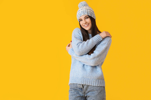 Beautiful young woman in winter clothes on color background - Foto, Bild