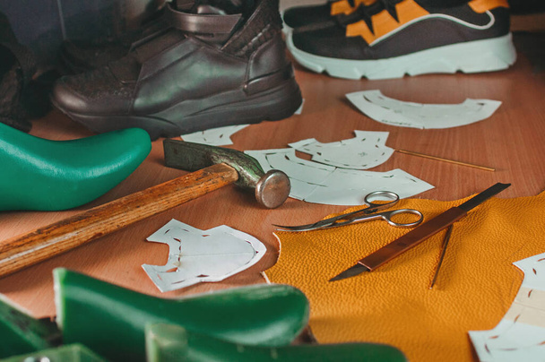 Sluiten van schoenmaker gereedschap op tafel in werkplaats. - Foto, afbeelding