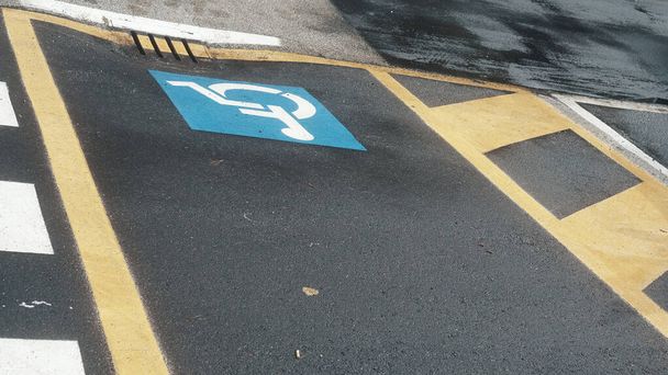 Behindertenparkplatz-Schild auf der Straße.  - Foto, Bild