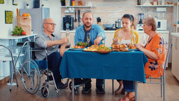 Handicap nonno e famiglia a cena - Foto, immagini