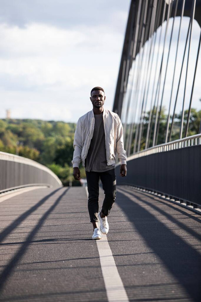 Confident young black man walking towards camera with confidence. Full length. Vertical.  - Foto, Bild