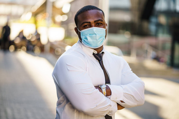 Portret van een verantwoordelijke zakenman met een beschermend masker. Covid-19 virus pandemisch concept. - Foto, afbeelding