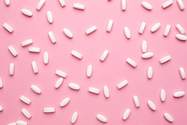 White vitamin pills to raise immunity on pink background, health and medical top view - Zdjęcie, obraz