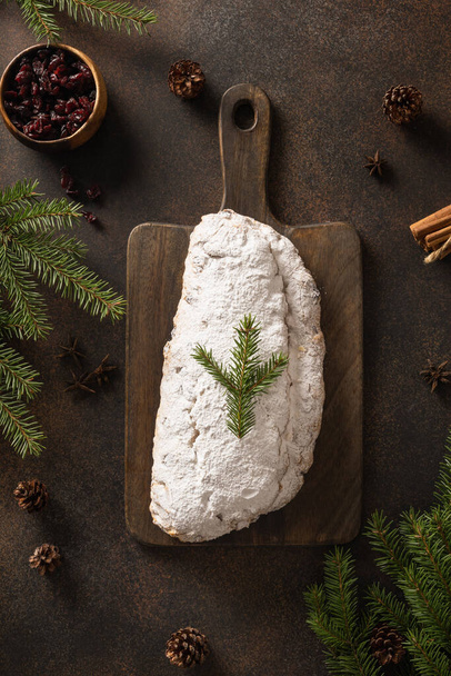 Christmas stollen - traditional German bread on brown background. Festive pastry dessert. View from above. Vertical format. - Photo, image