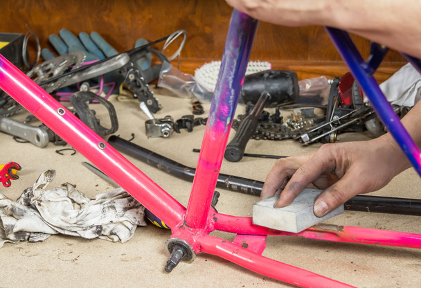 ręce prawdziwe rowerów mechanik szlifowanie ramy roweru - Zdjęcie, obraz