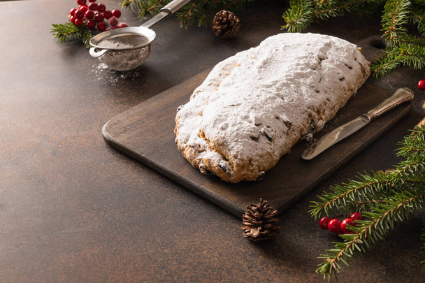 Christstollen - traditionelles deutsches Brot auf braunem Hintergrund. Weihnachtsgebäck Dessert. Kopierraum. Nahaufnahme. - Foto, Bild