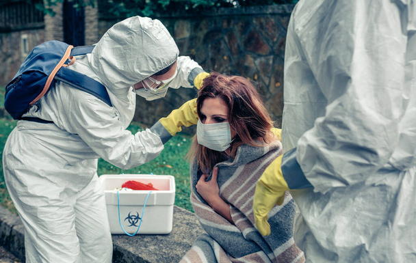Médicos colocando máscara protetora na mulher infectada com um vírus - Foto, Imagem