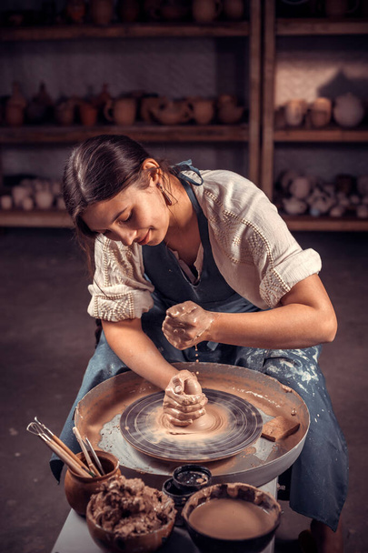 Чарівний кераміст робить керамічний горщик на гончарному колесі. Концепція для жінки у фрілансі, бізнесі, хобі
. - Фото, зображення
