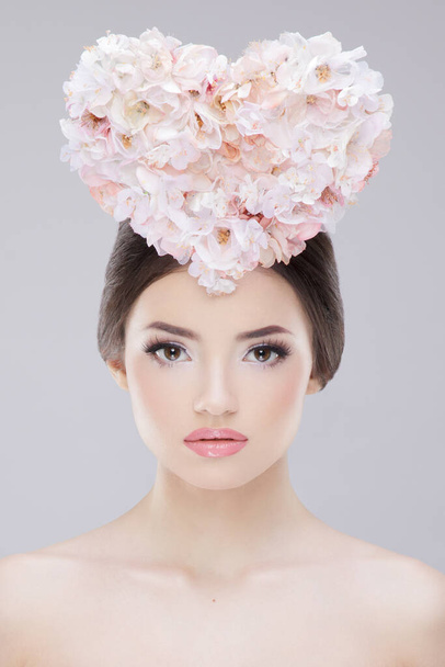Portret piękności. Piękna dziewczyna z wiosennymi kwiatami. Piękna Twarz. Kreatywny makijaż i styl włosów. - Zdjęcie, obraz