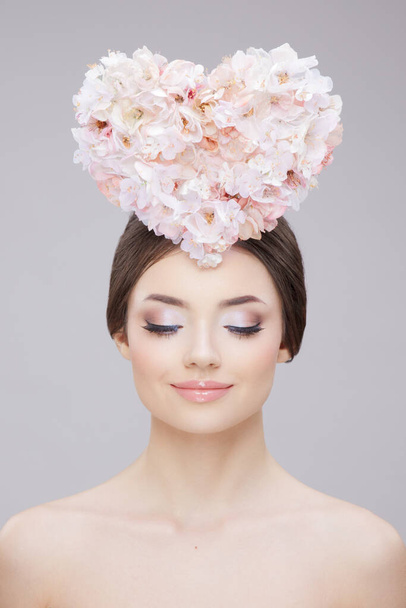 Retrato de beleza frontal. Menina bonita com flores de primavera, com olhos fechados. Maquiagem criativa e estilo de cabelo. - Foto, Imagem