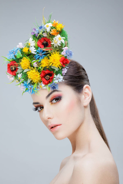 Profile beauty portrait. Cheerful girl with spring colorful flowers and bare shoulders, looking at camera. - Foto, Imagem