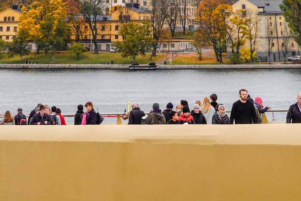 Stockholm, Svédország A gyalogosok átkelnek az új Slussbron, avagy Golden Bridge at Slussen, felavatott október 25, 2020. - Fotó, kép