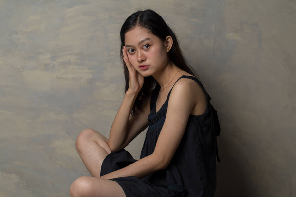 Asyalı kadın depresyonda ve yere oturuyor. - Fotoğraf, Görsel