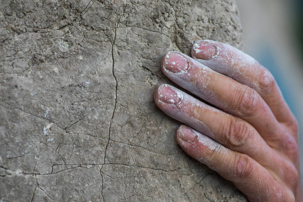 Plan rapproché d'un homme adulte tenant une main sur un rocher, illustration pour l'escalade. - Photo, image