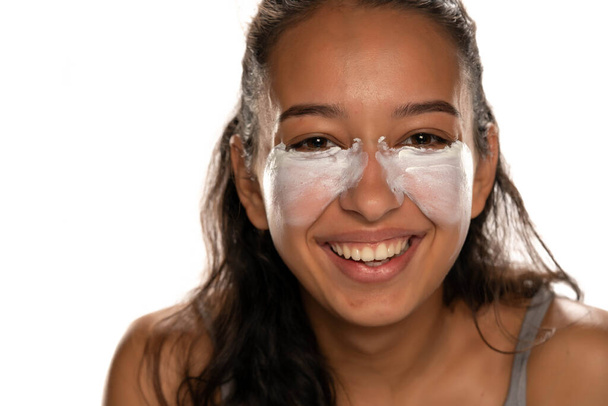 Nuori tumma iho nainen creme hänen matalat silmäluomet valkoisella pohjalla - Valokuva, kuva