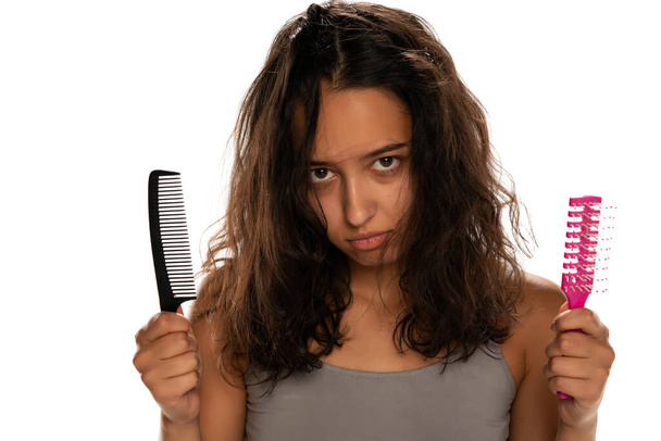 Giovane infelice donna dalla pelle scura con i capelli disordinati su sfondo bianco - Foto, immagini