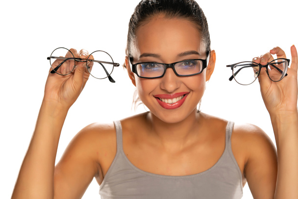 Young dark skinned woman compare the eyeglasses on white - Photo, Image