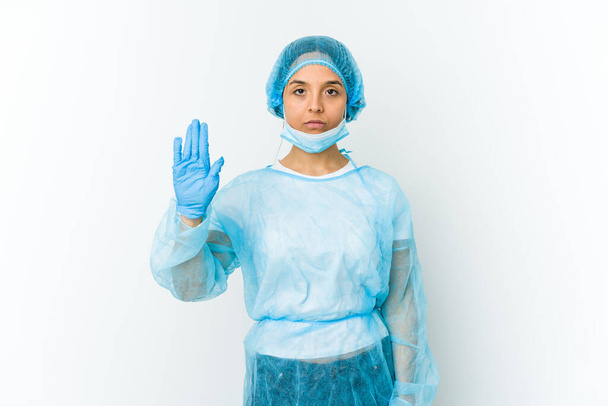 Молодая хирург латинская женщина изолированы на белом фоне стоя с протянутой рукой показывая знак стоп, предотвращая вас. - Фото, изображение
