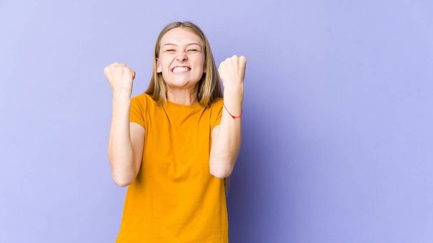 Young blonde woman isolated on purple background cheering carefree and excited. Victory concept. - Photo, Image