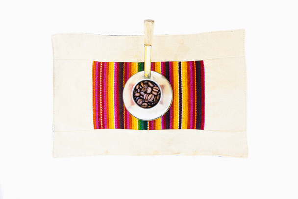Кофейные зерна в винтажном серебристом кофе чайник на красочный набор мат на белом фоне стола - Фото, изображение