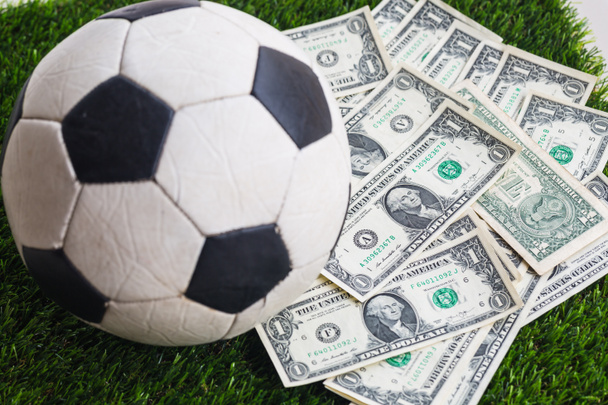  μπάλα ποδοσφαίρου με δολάριο νομοσχέδιο στο γρασίδι φόντο - Φωτογραφία, εικόνα