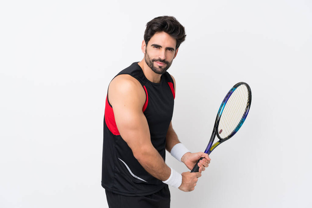 Young handsome man with beard over isolated white background playing tennis - Photo, Image