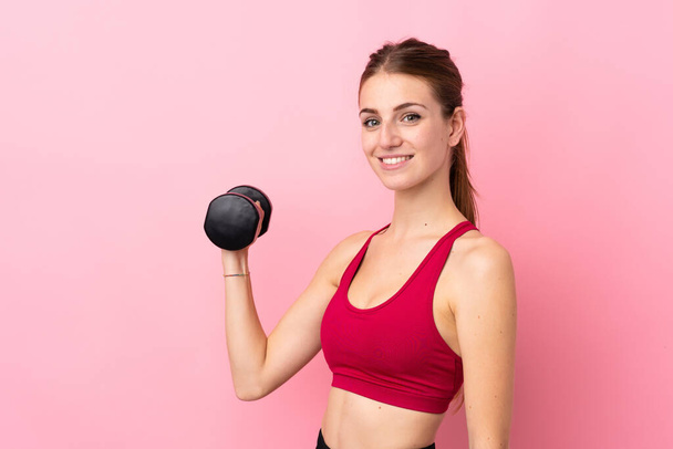 Jovem mulher esporte sobre isolado fundo rosa fazendo levantamento de peso - Foto, Imagem