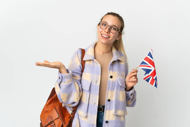 白地に英国の旗を掲げた若いブロンドの女性が笑顔を見せながらアイデアを提示 - 写真・画像
