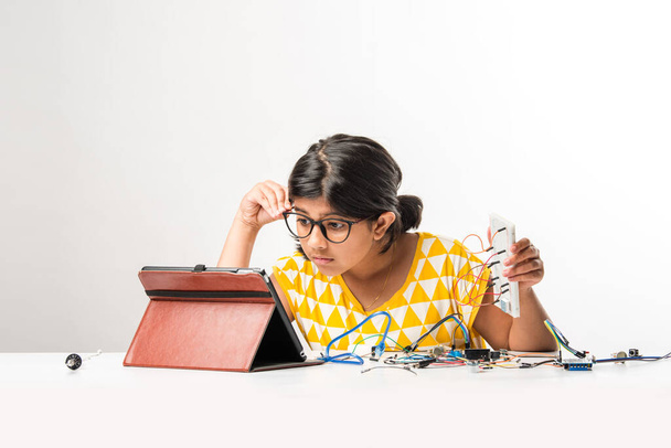 experimento electrónico - Asiática india niña estudiante realizar o estudiar ciencias con cables, conexiones, estudiar desde el ordenador portátil o tableta - Foto, imagen