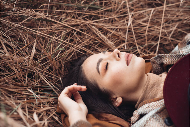 Foto de moda ao ar livre de jovem bela senhora na paisagem de outono com grama seca. Camisola de malha, batom de vinho. Outono quente. - Foto, Imagem