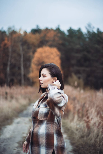 Junge Frau modisch gekleidet in einem trockenen Herbstwald - Foto, Bild