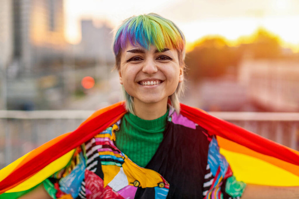 Portrait of a gender fluid person wearing rainbow flag - Photo, Image