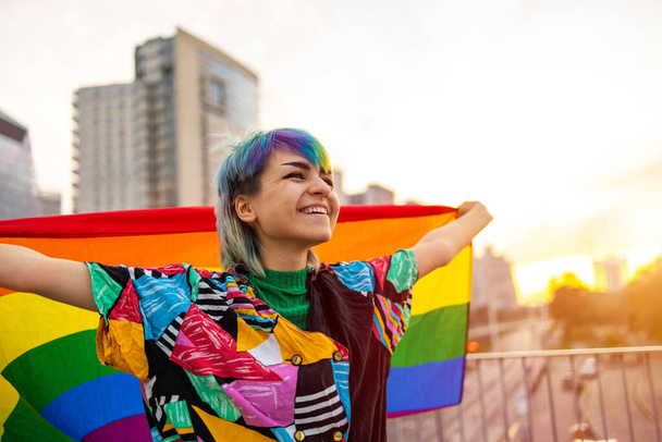Πορτρέτο του ευτυχούς μη δυαδικού προσώπου κυματίζει σημαία ουράνιο τόξο - Φωτογραφία, εικόνα