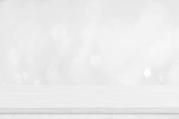 Weiße Holztischplatte über unscharfem weißem Bokeh-Hintergrund. Leeres Holzregal für Produktpräsentation, Banner oder Attrappe. - Foto, Bild