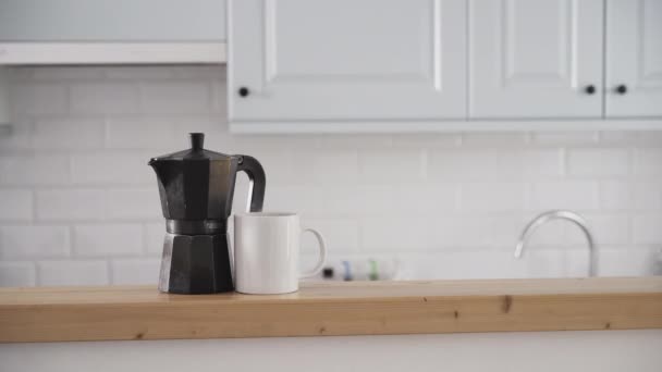 Vista frontal de uma cafeteira e uma xícara de café no balcão da cozinha. - Filmagem, Vídeo