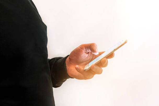 Мужской палец указывает на экран смартфона, общается в социальных сетях, использует текстовый мессенджер или онлайн - Фото, изображение