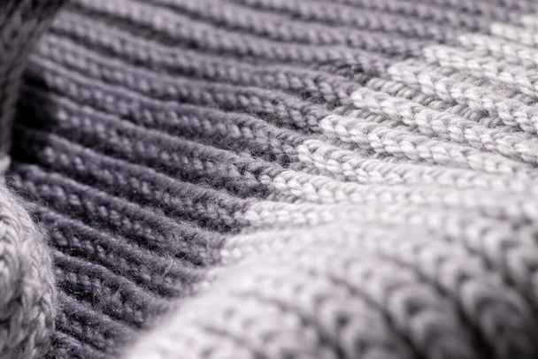 Серая двухтоновая текстура шерстяного шарфа. Изделие ручной работы, крупный план, селективная фокусировка - Фото, изображение