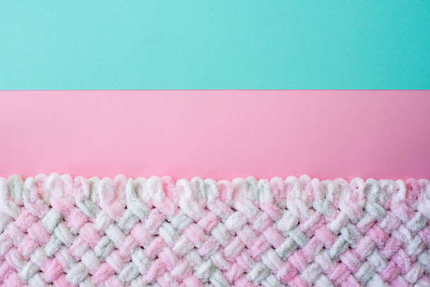 暖かい毛布、フラットレイアウト、トップビューを持つ小さな編んだ赤ちゃん。ピンク、青、ミントの背景にニットブランケット。青とピンクの編み物の質感の背景、暖かい毛布. - 写真・画像