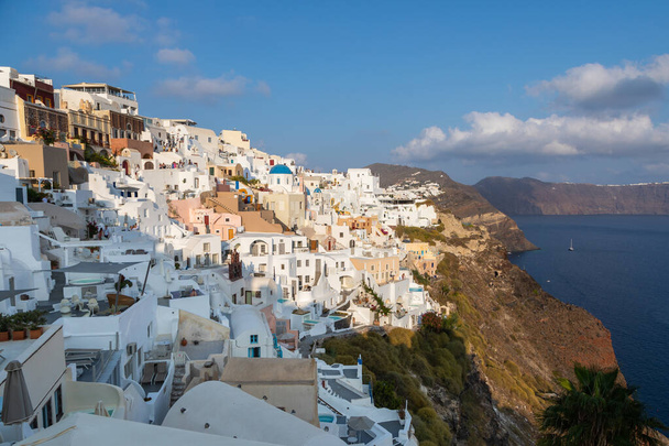 Oia, Santorini Island, Greece- 18 September 2020: Scenic view of famous, traditional cycladic white architecture in the village. Sunset vie point. - Foto, Imagen