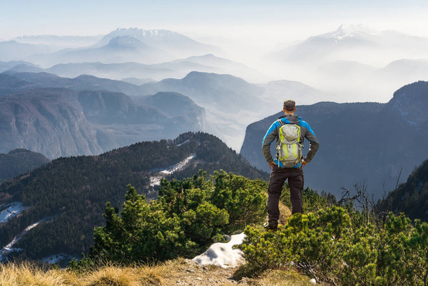 Man hiking on mountain trail. Great view above the clouds and fog. - Photo, Image