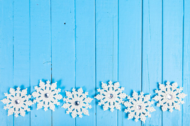 Christmas. Snowflakes on a blue wooden background. Beautiful festive background.Border. - Valokuva, kuva