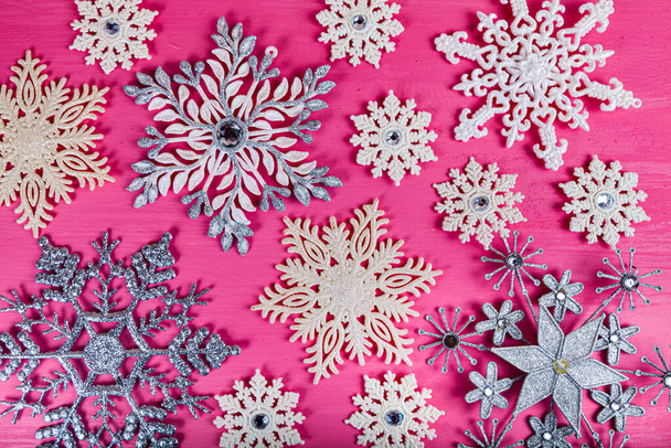 Christmas. Snowflakes on a pink wooden background. Beautiful festive background. - Foto, Imagem