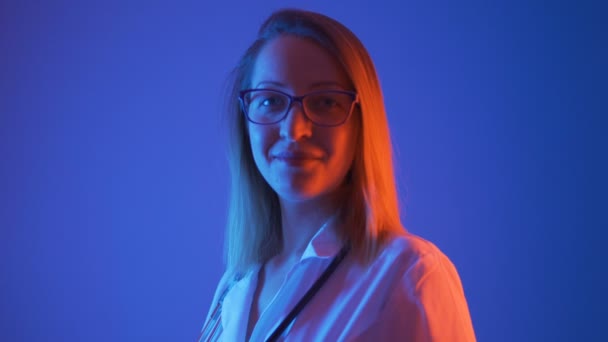 Портрет женщины-врача в очках и белом халате, закрытый в помещении - Кадры, видео