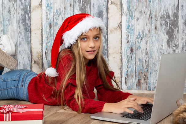 blonde girl using laptop at christmas to communicate - Фото, изображение