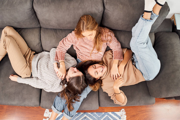 Top view of three girlfriends on the sofa at home. - Foto, imagen