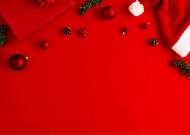 2020 Nowy Rok Boże Narodzenie prezentuje Santa kapelusz z prezentami i dekoracjami świątecznymi na czerwonym papierze tło przestrzeń kopia Top view with copy space. - Zdjęcie, obraz