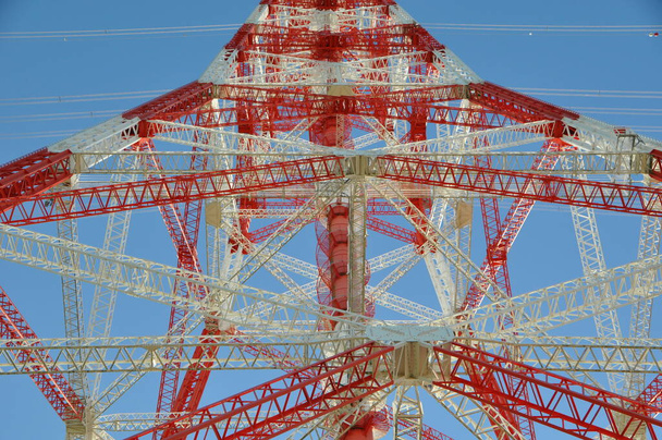 Hochspannungsmast gegen blauen Himmel in rot und weiss - Φωτογραφία, εικόνα